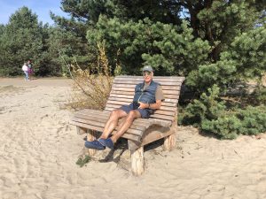 Normen entspannt auf einer Holzbank auf der Kurischen Nehrung